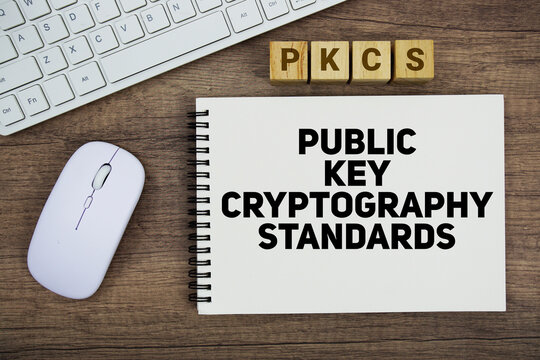 PKCS Public Key Cryptography Standards message with keyboard and optical mouse on wooden background