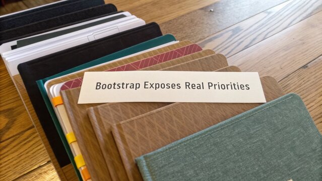 Organized Notebooks on Wooden Table with Note About Bootstrapping that Highlights Its Real Priorities for Productivity and Focus in Work Life