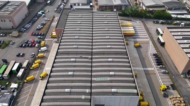 Hyperlapse drone footage of parcel distribution hub in San Giuliano Milanese, Lombardy, Italy. Urban logistics center and last mile delivery warehouse during active morning operations.