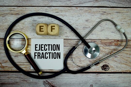 Ejection Fraction (EF) text with stethoscope and magnifying glass on wooden background