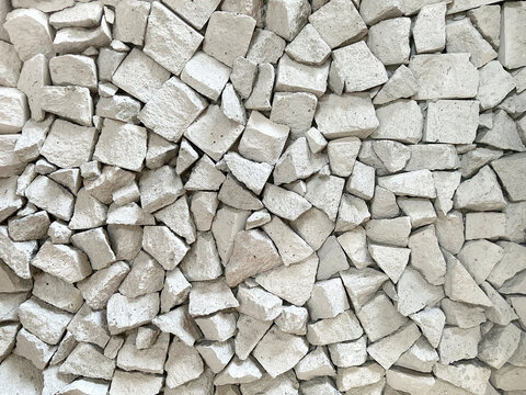 Close up of natural random cut grey beige cobble stone or flag stone gravels. Rough flagstone and gravel stacked randomly, for floor or wall finishes. Seamless background texture.    