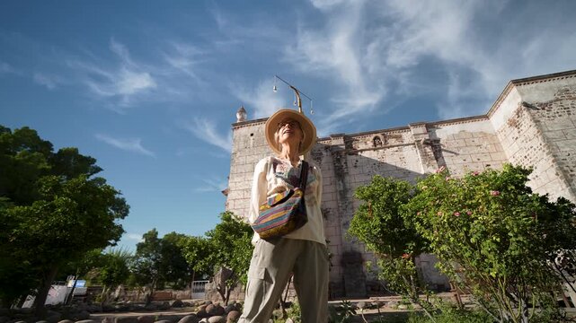 Woman explores Mission Church in San Ignacio Baja California Mexico capturing memories with her camera enjoying the scenery