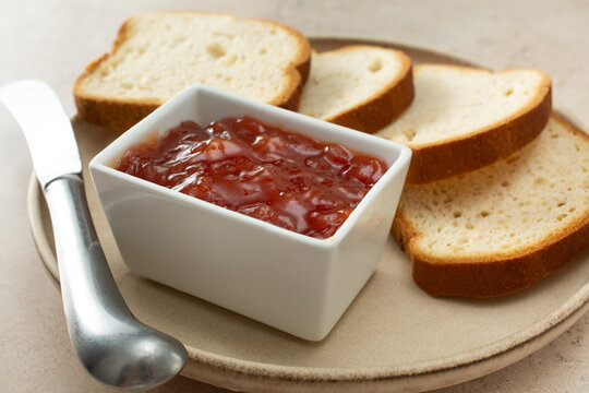 A view of a square condiment cup of guava preserves.
