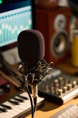 Vertical shot of studio microphone standing before audio editing workstation, recording podcast or...