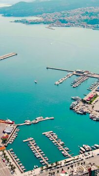 Vertical video. Kavala, Greece. Embankment and port. Historic city center. Aegean Sea. Summer. Drone footage. Rich colors