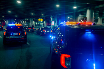 Police patrol car with illuminated lights. Police operate on city roadway at night. Police vehicle shows enforcement authority. Police provide public safety and security. © Volodymyr