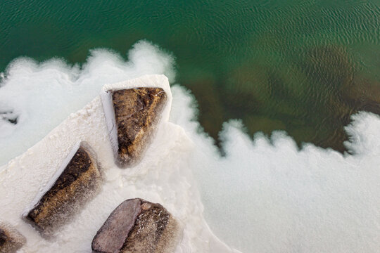 Ice building up on the rocks and shallow water of Lake Michigan in Wisconsin
