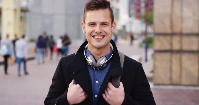 Commute, face or businessman in city with headphones, optimism or morning travel in work routine. Happy, portrait and person in town with tech, employee journey or positive attitude at start of day.