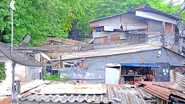 Overhead view of a dense urban neighborhood with corrugated metal roofs and tangled wires