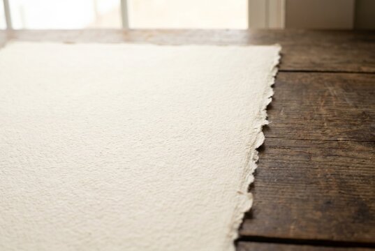 Handmade paper with deckle edge on rustic wooden table