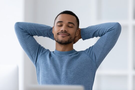 Man taking break from computer and stretching arms, work-life balance, sstkHealth