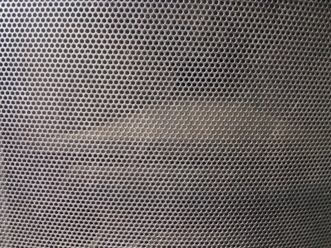 Close-up abstract gray mesh texture with a repetitive perforated pattern, creating a modern industrial background for digital and architectural designs.
