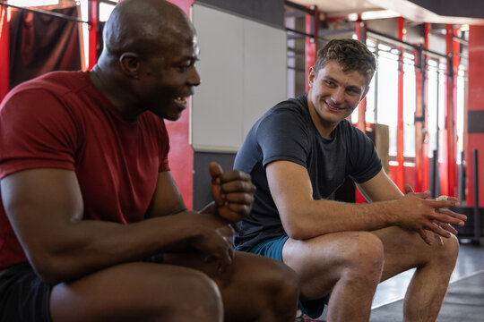 Two men talking post-set, animated fitness rep counter rising beside them to plan next set