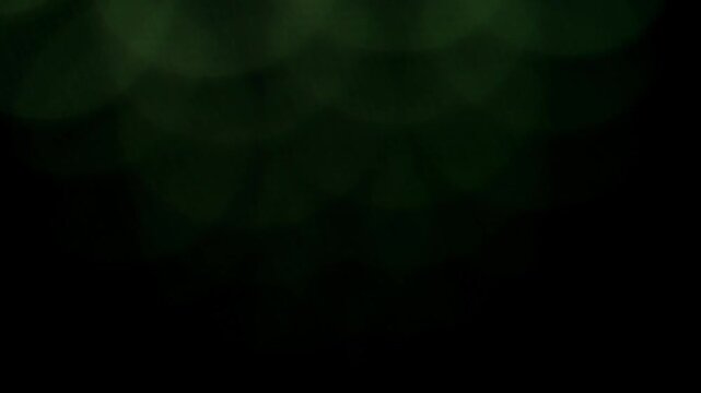 Seamlessly looping transitions of blue green and warm-toned defocused light particles.