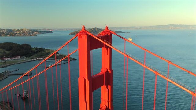 Drone view of Golden Gate Bridge tower with blue bay water and Alcatraz Island