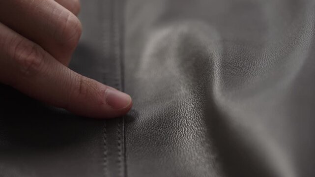 Slide shot man touching fine leather seam closeup