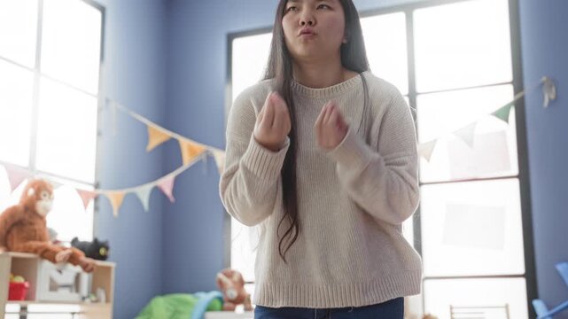 Woman reaching hand forward toward camera in a kids studio with bunting and plush monkey on shelf; quiet contemplation.