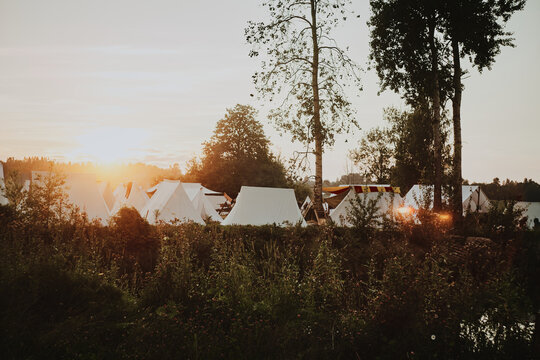 Campsite with white tents among the trees and bushes