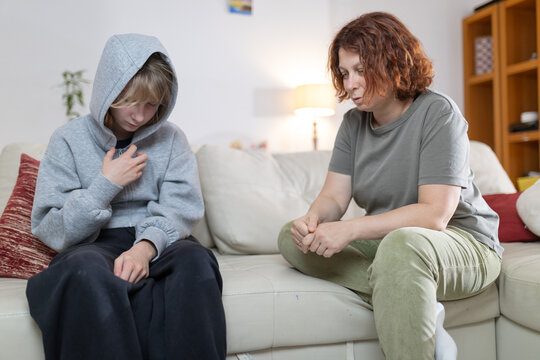 Mother comforting upset teenager dealing with difficult issue