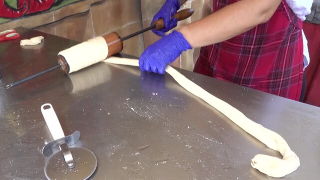Baker preparing traditional hungarian kurtoskalacs chimney cake dough