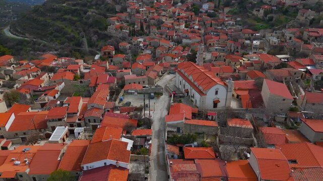 Aerial Rising Shot of Historic Lofou Church with Downward Tilt Over Traditional Cyprus Village