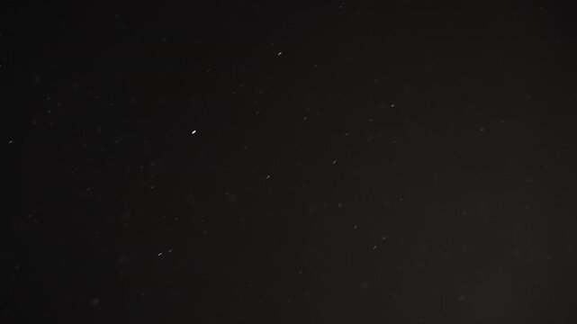 Real dust particles floating mid air over dark background