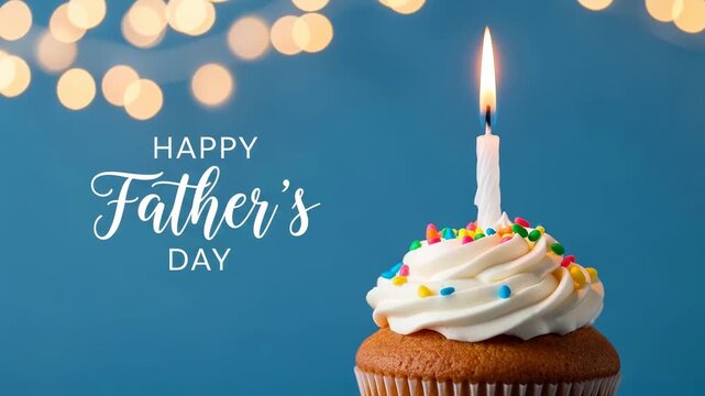 Closeup of a festive cupcake with a lit candle and colorful sprinkles beside "happy father's day" lettering against a blue bokeh background
