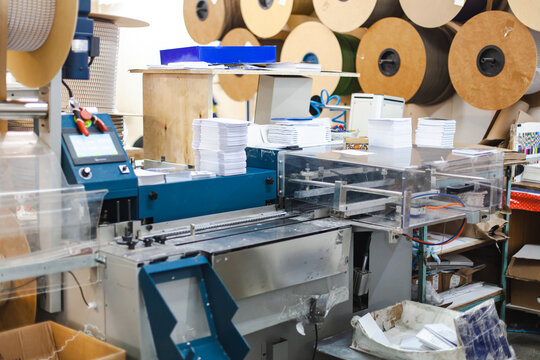 Automated printing and finishing workflow in commercial printshop - machinery for folding, stacking and processing large volumes of paper. Printing and finishing operations in production environment.