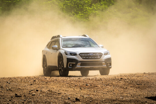 Brno, Czech Republic - May 15, 2025: Subaru Outback driving off-road in sand and dust. Lots of dust and smoke around the car. Family SUV off-road.