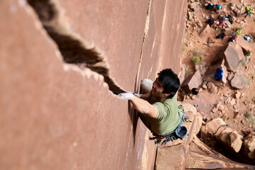 Rock climber crack climbing sandstone wall with determination © Seth