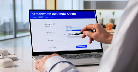 Naklejka premium Man Reviewing Home Insurance Rates On Laptop