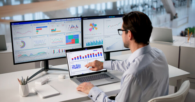 Mature Financial Analyst Studies Market Charts On Laptop