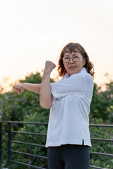 Obraz premium Senior old asian woman wearing sportswear warming up before running outdoor. Portraits of Mature woman stretching body before running. Training work out at outdoor activity for older adults