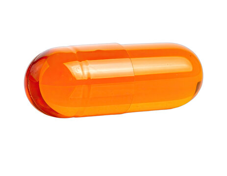 A vibrant orange capsule is isolated against a stark black background, highlighting its smooth, elongated form and reflective surface.