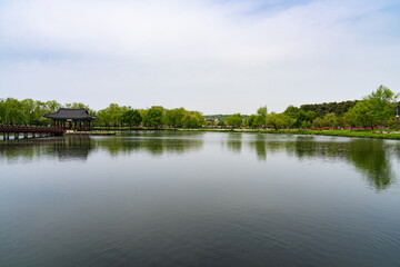 Obraz premium Serene View of Ancient Royal Pond with Traditional Architecture