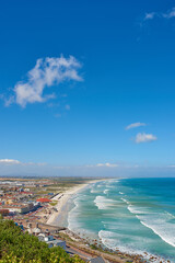 Beach, city and blue sky with nature for outdoor travel, tourism or getaway resort with mockup space. Above of waves or landscape background with sea or ocean for holiday, vacation or destination © peopleimages.com