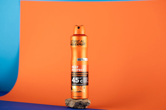 L&rsquo;Or&eacute;al Men Expert Heat Protect antiperspirant deodorant spray presented in a modern minimalist product photography composition with vibrant orange and blue tones emphasizing freshness, protection and