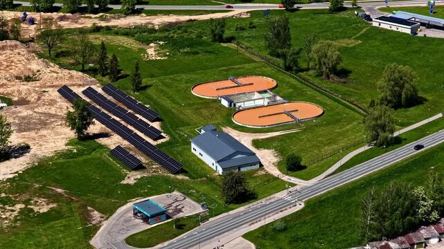 Slow drone zoom showing circular oxidation ditches and solar energy panels in Bauska.