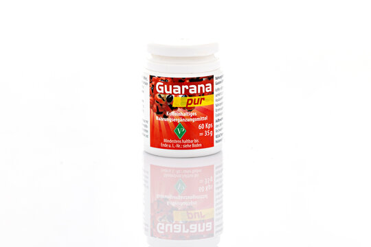 Guarana Pur caffeine supplement capsules in small retail container isolated on light background. Illustrative editorial studio product photography of dietary supplement packaging.