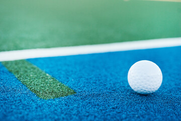 Hockey, closeup and ball with empty pitch for training, outdoor practice and tournament with space. Floor, ground or astro turf with match, game or recreation activity at venue, field or sports club © peopleimages.com