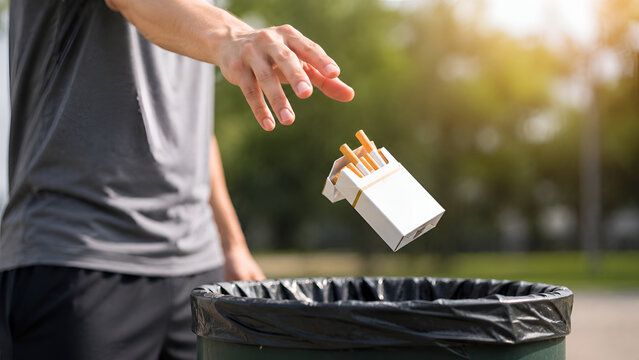Person Throwing Cigarette Pack into Trash Bin Outdoors Representing Smoking Cessation Healthy Choices and Tobacco Free Lifestyle