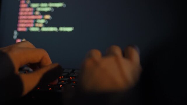 An IT engineer rapidly types complex algorithms on a keyboard, refining an artificial intelligence model on a high-tech computer display, illustrating the intersection of automation, technology