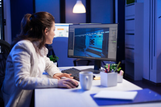 Woman working intently at computer with architectural or 3D modeling software in modern office setting