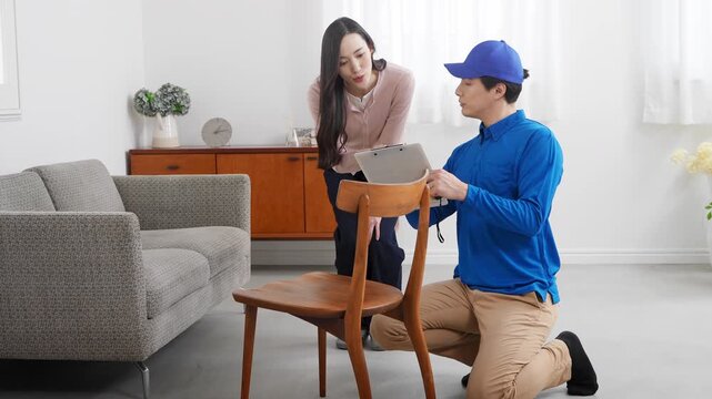 若い女性の引っ越しの見積もりをする若い業者　ライフスタイルイメージ	
