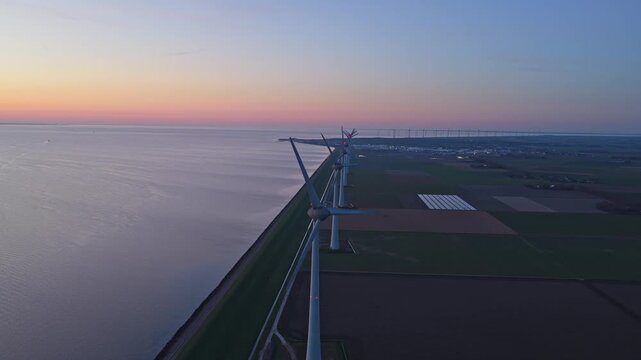 Wind turbines generating clean energy at sunset at Flevoland