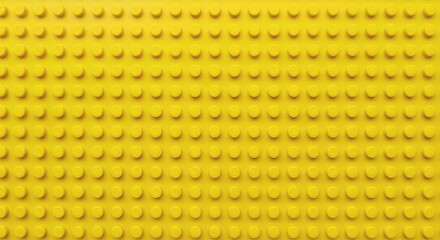 Fototapeta premium Yellow plastic building block plate texture background for kids toys