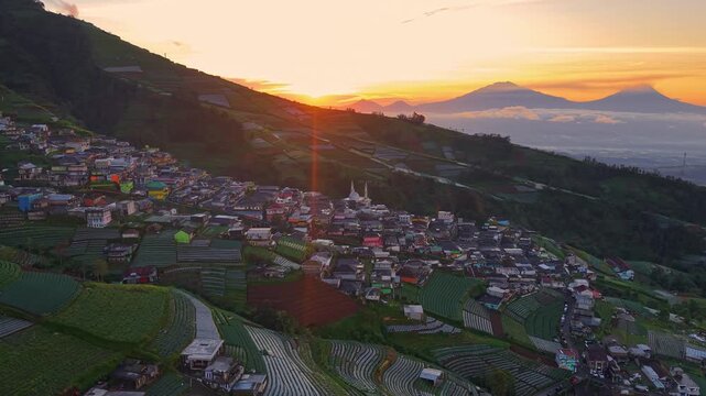 Beautiful sunrise over countryside village, terraced fields and homes under glowing morning sky. Nepal Van Java, Indonesia.