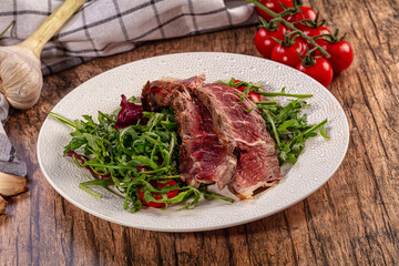 Fototapeta premium Gourmet Roast Beef Slices Fresh Arugula Salad Cherry Tomatoes Garlic Chili Pepper