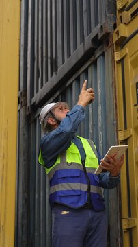 Professional logistics worker inspecting cargo containers at warehouse yard. Shipping, freight transport