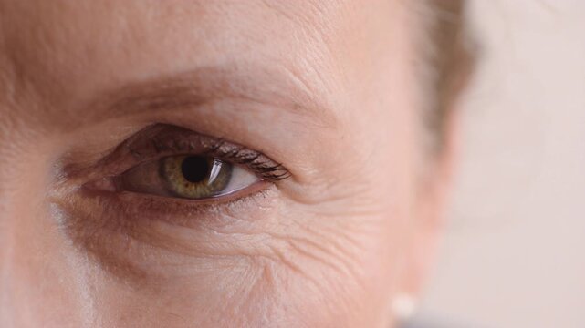 Eye, face and health with mature woman for optometry exam, eyesight vision and myopia test. Closeup, ophthalmology and ocular care with person, optical assessment and white background in studio